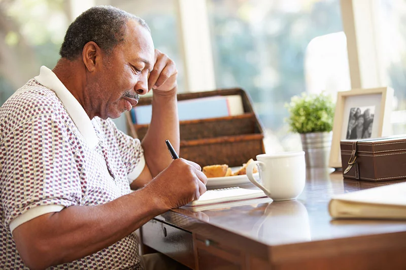 senior man writing about diabetes and dental care