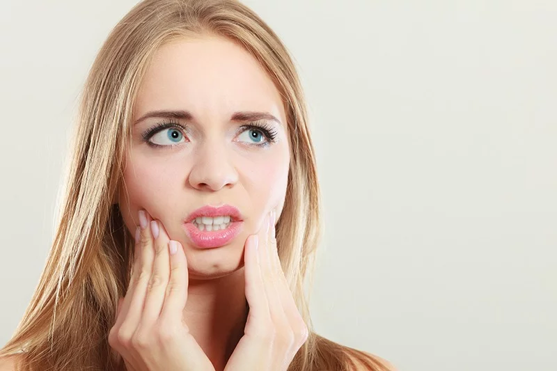 young woman with wisdom tooth pain
